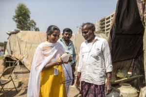 Woman selling solar light to customer in India slum